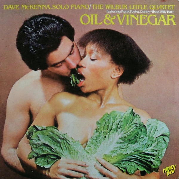 Part of Worst Record Covers. A couple kidding. The man is standing behind the woman and the woman is covering her breasts with large lettuce leaves.